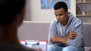 a teen in adolescent bipolar disorder treatment listens to a therapist
