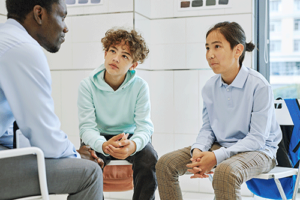 teens talk to a therapist in a family support and treatment program 