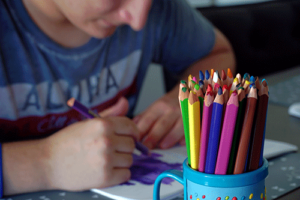a teen colors a picture in an art therapy program 