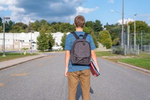 a teen stands ready to go to school, poossibly wondering about signs of bipolar disorder in teens