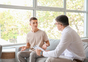 a teen talks with a therapist during adolescent marijuana addiction treatment