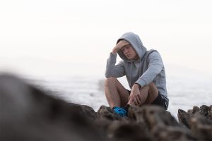 an angsty teen sits outdoors