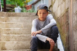 a teen looks stressed sitting on stairs, wondering about adhd vs. add in teens