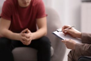 a teen listens to a therapist during individual therapy