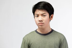 a teen looks angry as he deals with the connection between teen stress and anger