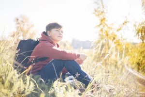 a teen smiles outside during long-term residential treatment