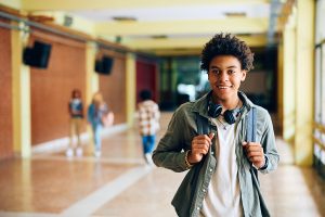 a boy smiles in front of an academic program at residential treatment for adolescents