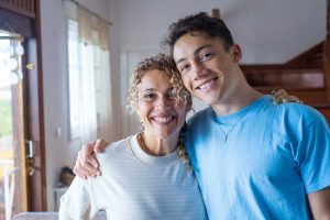 a mom and teen smile and embrace after finding the best mental health services for teens