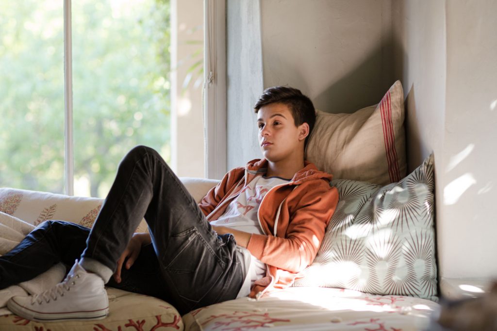 a teen with adhd and impulse control issues sits in bed