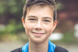 a teen boy smiles at a summer treatment program for adhd