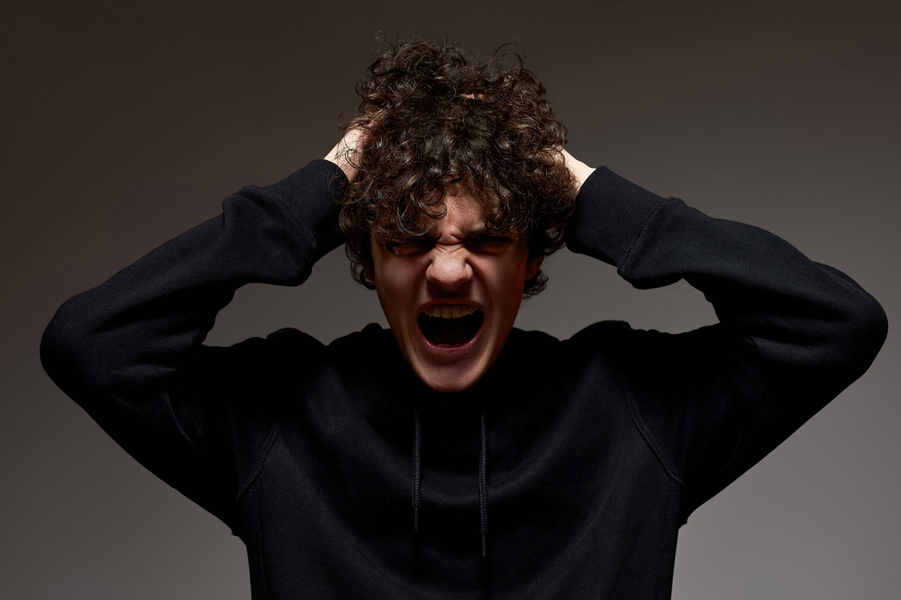 a teen screams as he experiences anger and puberty
