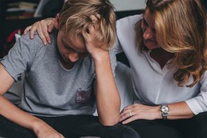 a mother comforts her son as he struggles with depression and autism