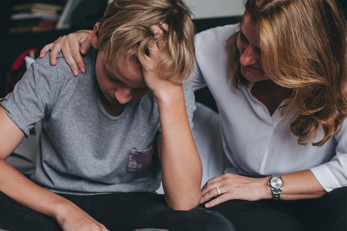 a mother comforts her son as he struggles with depression and autism