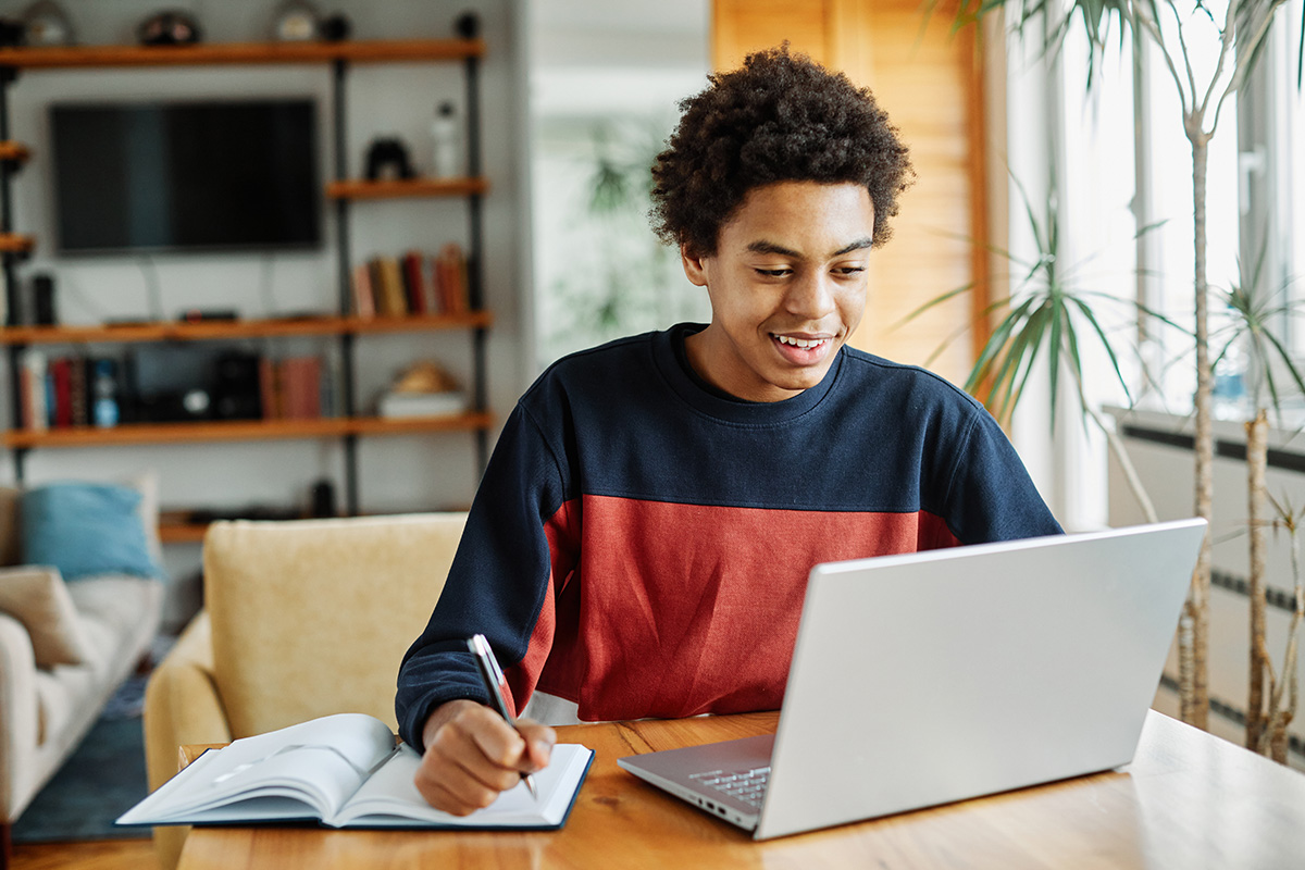 a teen works on homework on a computer after creating an adhd routine